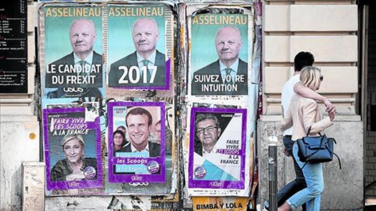 Colaje de carteles electorales en una pared de un edificio de París.-CHARLES PLATIAU