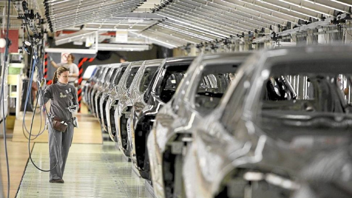 Una trabajadora revisa una cadena de automóviles del modelo Megane en la fábrica de Renault en Villamuriel.-ICAL