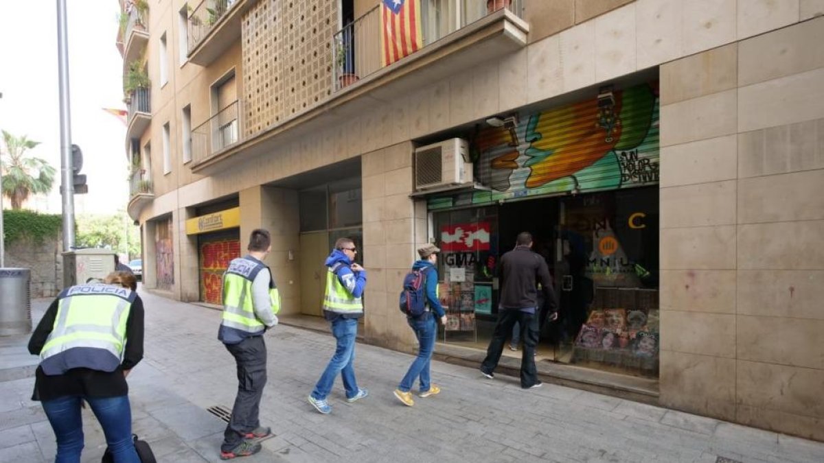 Agentes de la Policía Nacional entran en la sede de la Fundació CATmón.-/ RICARD FADRIQUE