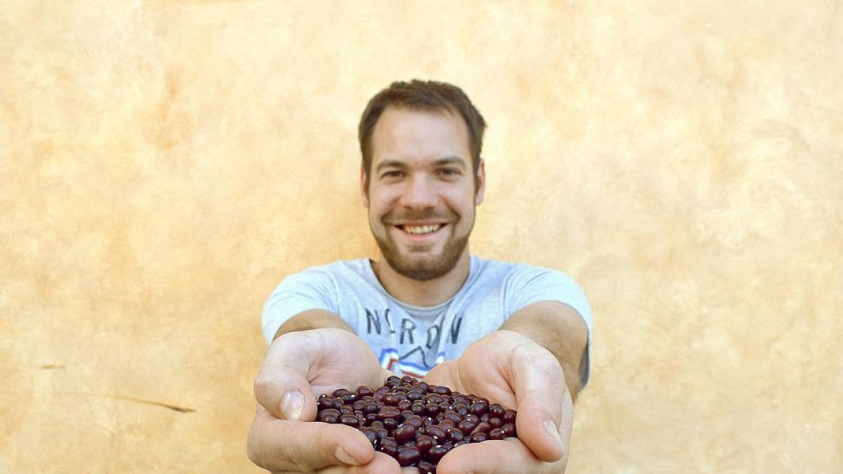 Alejandro Fuentes, cultivador de alubia roja de Ibeas y presidente del colectivo que la defiende desde hace casi dos décadas, con un puñado de legumbres recién cosechadas.-ARGICOMUNICACIÓN