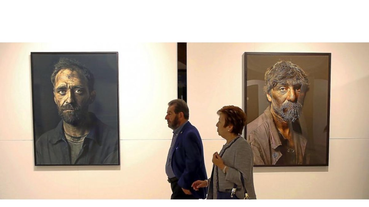 Dos visitantes contemplan las obras del fotógrafo francés Pierre Gonnord expuestas en el parlamento autonómico.-ICAL