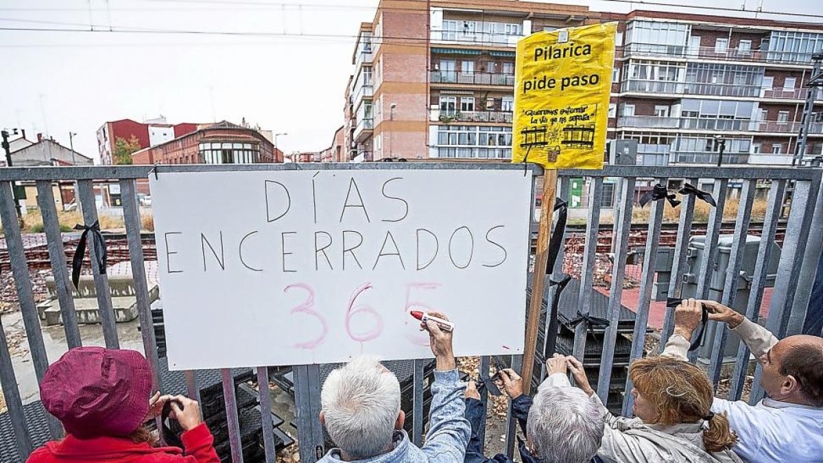 Los vecinos colocaron un cartel junto a la valla del tren recordando los 365 días de «encierro» del barrio. P-PABLO REQUEJO