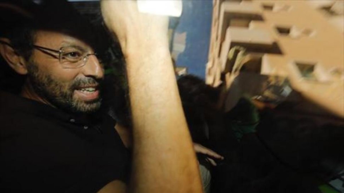 Sandro Rosell, en un coche policial, tras su detención en Barcelona.-FERRAN NADEU