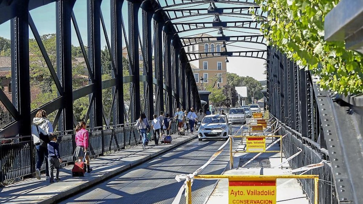 Vallas y balizas impiden el paso en una de las aceras del Puente Colgante, ayer, durante el inicio de las obras de reparación.-J.M. LOSTAU