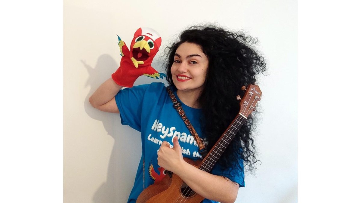 La berciana Laura Núñez, ukelele en mano, junto al protagonista de sus clases de español, el loro Pepe. / E.M.