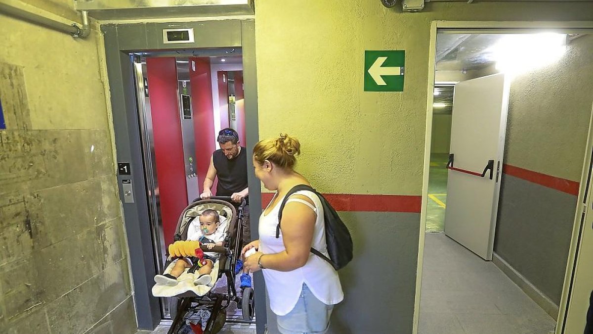 Una familia accede al aparcamiento por el ascensor de la entrada principal.-J.M. LOSTAU
