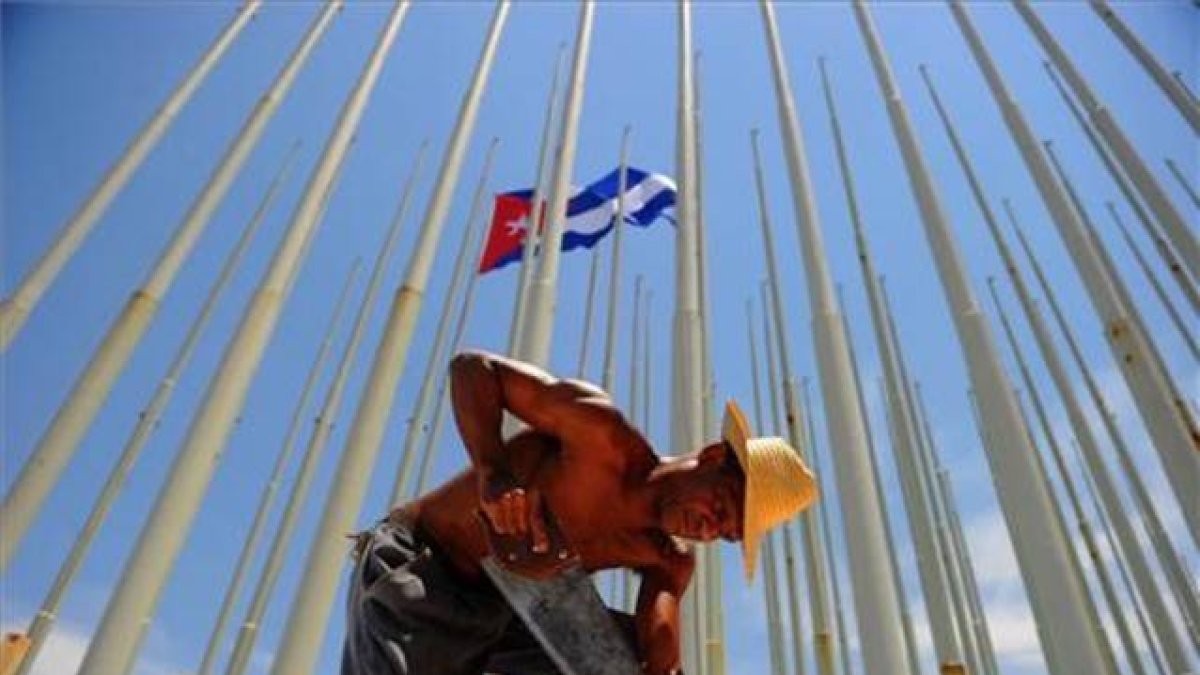 Trabajadores cubanos preparan el recinto donde se celebrará la ceremonia de izada de bandera en la embajada de Estados Unidos de La Habana.-AFP / YAMIL LAGE