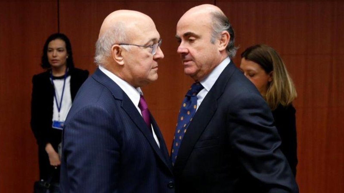 Michel Sapin habla con Luis de Guindos en la reunión del Eurogrupo.-FRANCOIS LENOIR