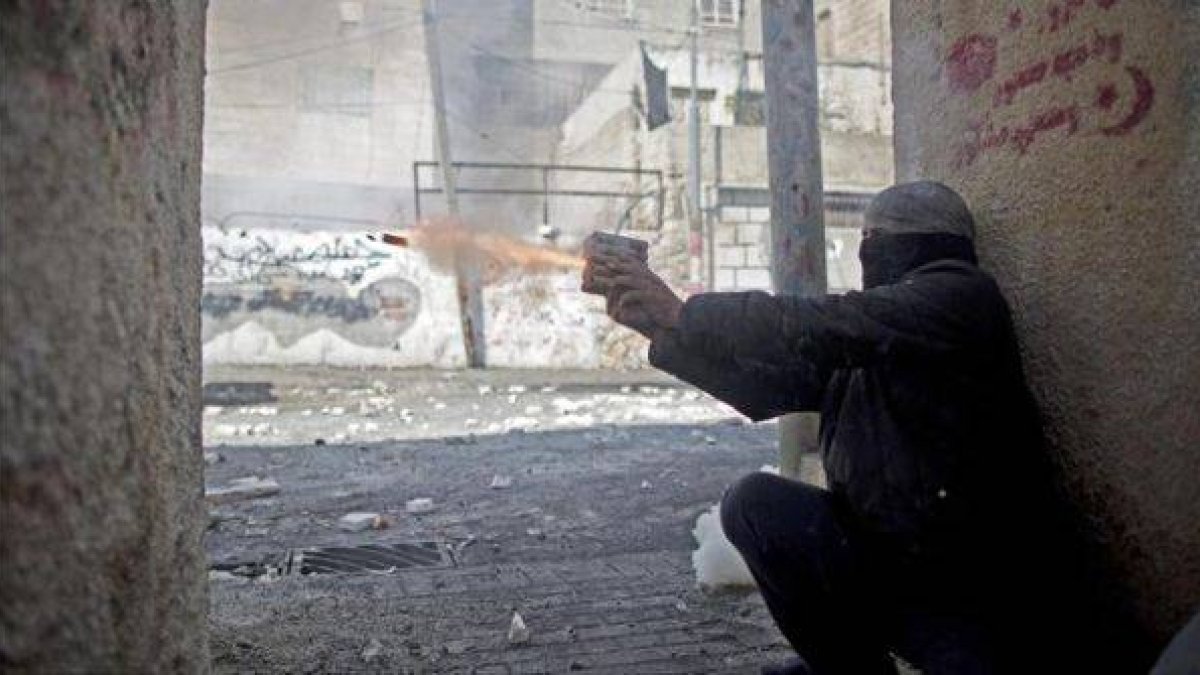 Un palestino lanza un petardo a las fuerzas de seguridad israelís.-Foto: EFE / ABIR SULTAN
