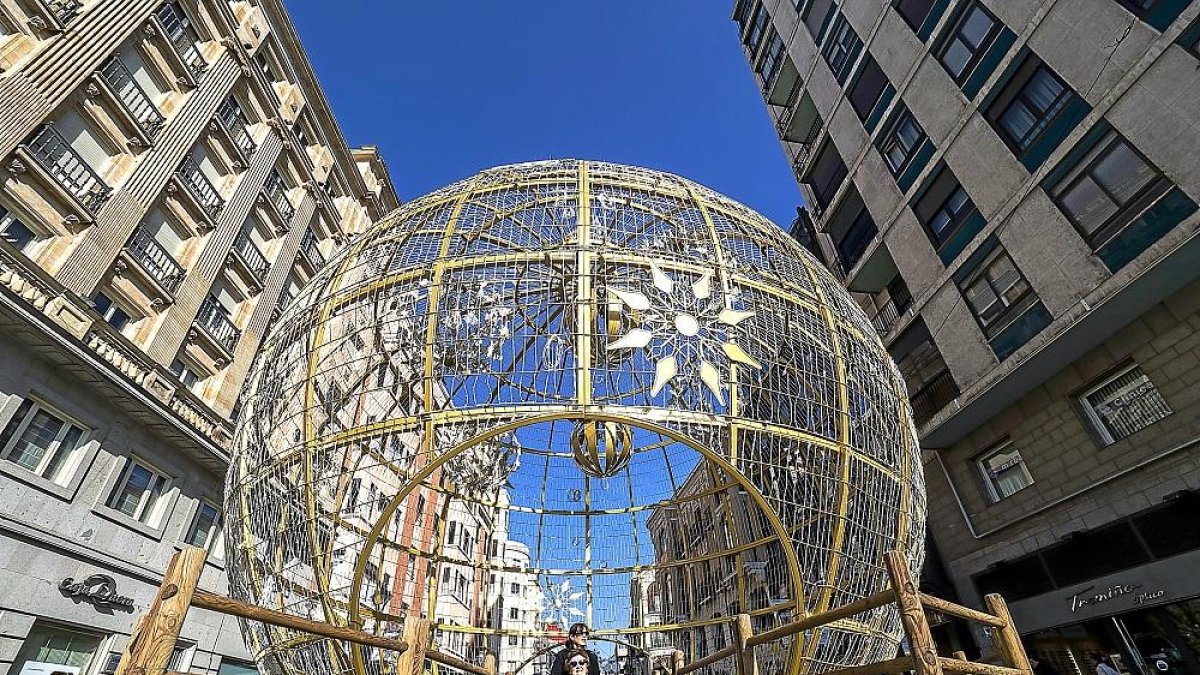 Algunos ciudadanos ya han pasado por dentro de la gran bola de Navidad antes del iluminado.-PABLO REQUEJO / PHOTOGENIC