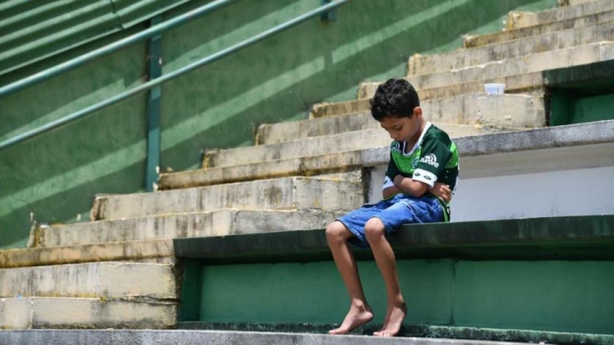 Un niño llora a sus ídolos desaparecidos en el estadio del Chapecoense.-AFP / NELSON ALMEIDA