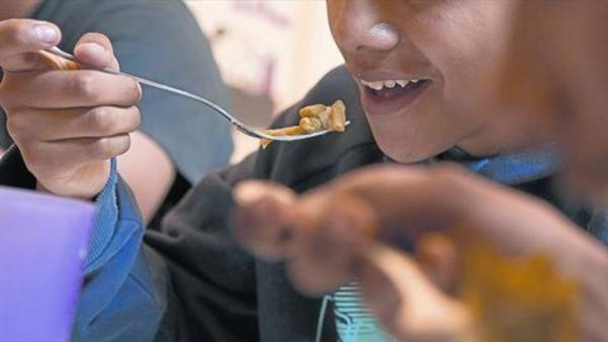 Unos niños en un comedor social de una entidad en el barrio del Raval, en Barcelona.-Foto:  FERRAN NADEU