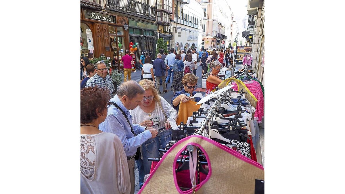 Viandantes buscando prendas en stock en uno de los burros de ropa en la calle Regalado.-MIGUEL ÁNGEL SANTOS/ PHOTOGENIC