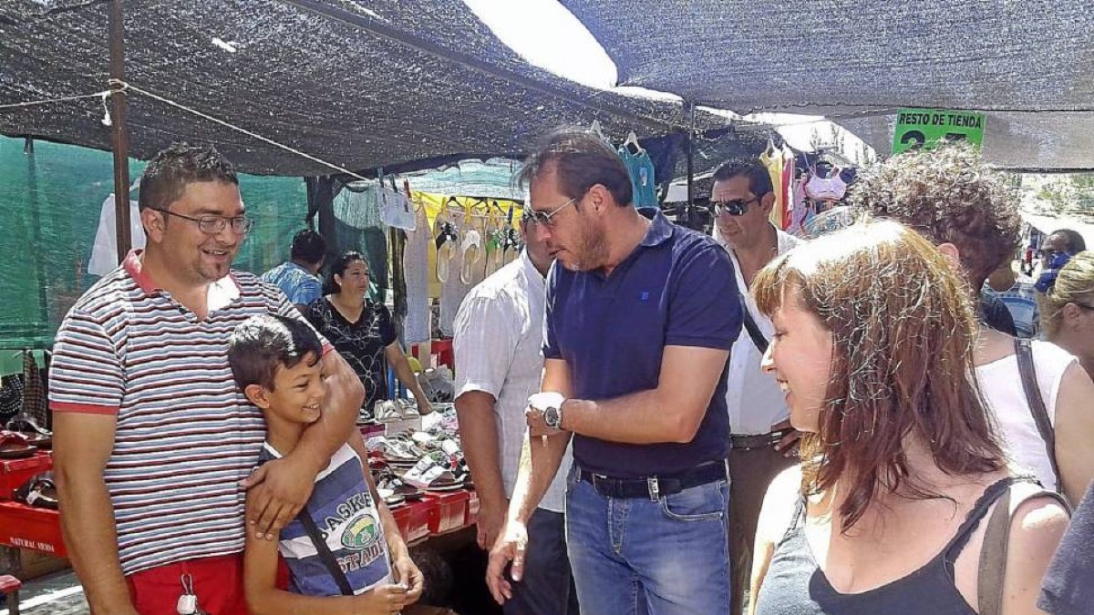Óscar Puente conversa con un vendedor ambulante y su hijo, en el mercadillo del estadio.-El Mundo