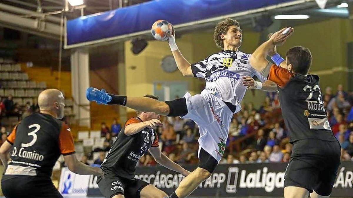 Acacio Marqués lanza a portería delante de Mouriño en el partido de ida en León.-JESÚS F. SALVADORES