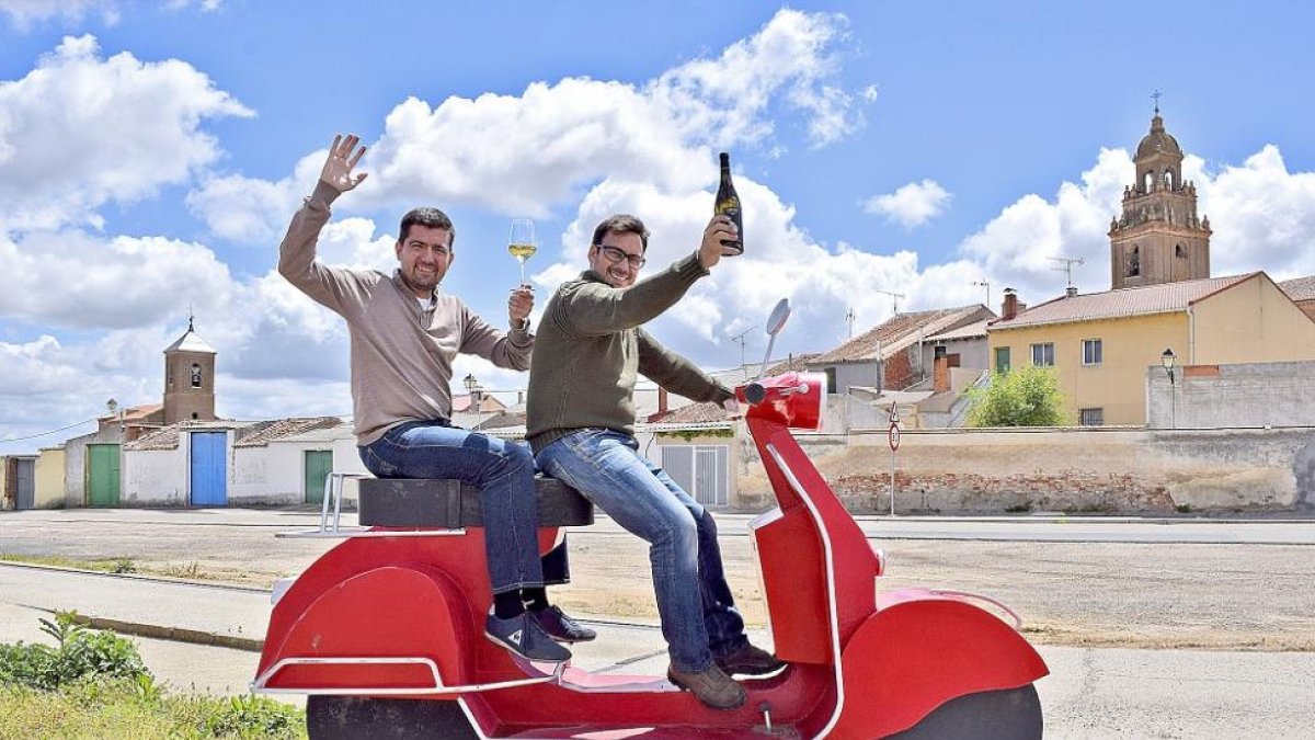 Miguel Ángel e Ignacio ya se han subido a la moto del vino, y lo hacen de forma simbólica sobre la escultura del artista local Juan Antonio Martín Carrión, en Pozaldez.-ARGICOMUNICACIÓN