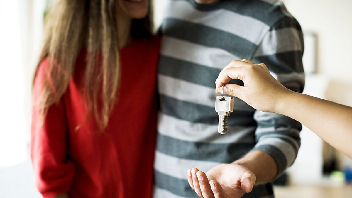 Una pareja joven obtiene la llave de su vivienda. PQS / CCO