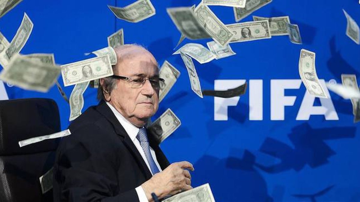 Joseph Blatter, rodeado de billetes lanzados por un espontáneo durante una rueda de prensa en la sede de la FIFA en Zúrich.-AFP / FABRICE COFFRINI