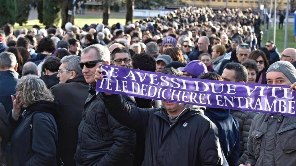 Un aficionado sostiene una bufanda de la Fiorentina durante el funeral de Davide Astori-MAURIZIO DEGL INNOCENTI