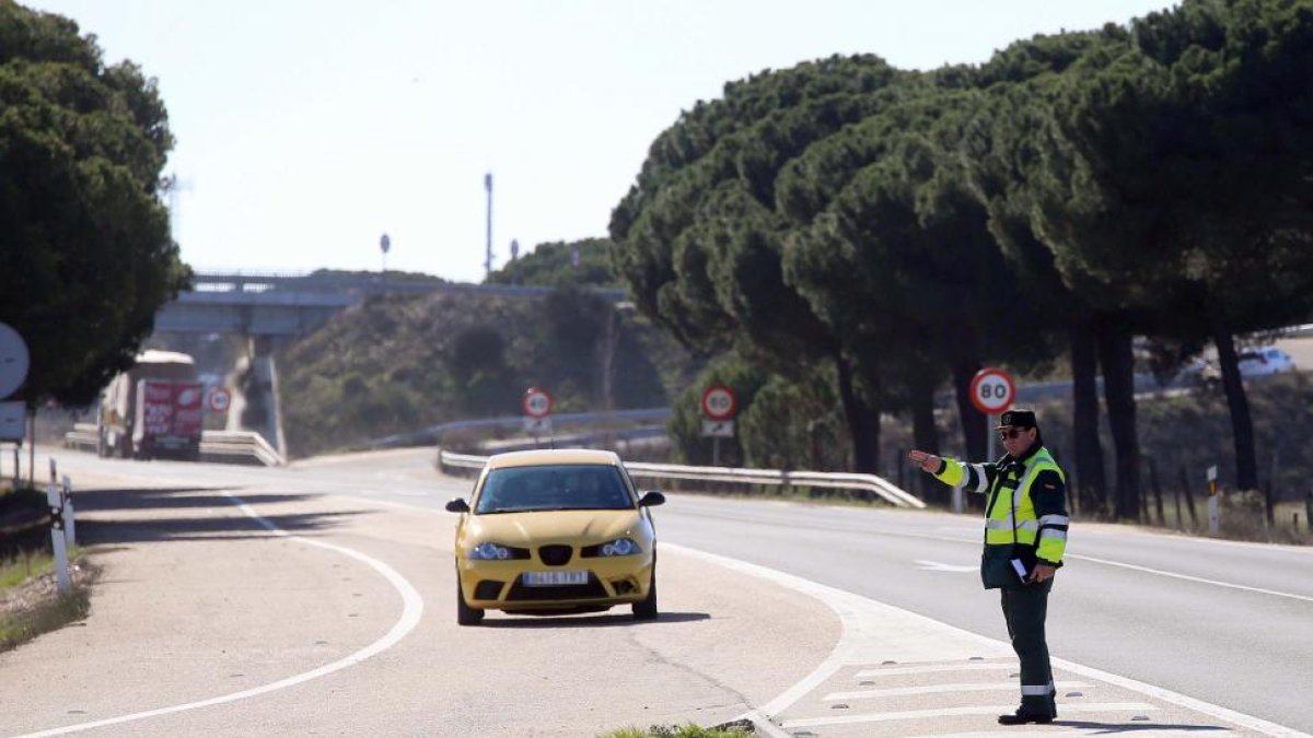 Un agente de la Guardia Civil indica a un vehículo que pare tras un control de velocidad.-ICAL