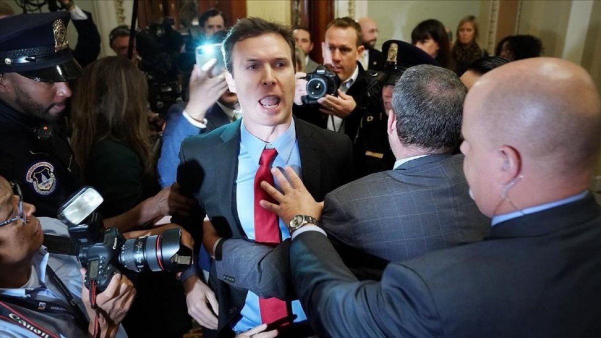 Ryan Clayton increpa a Trump en el Capitolio tras lanzarle pequeñas banderas rusas.-AFP / CHIP SOMODEVILLA