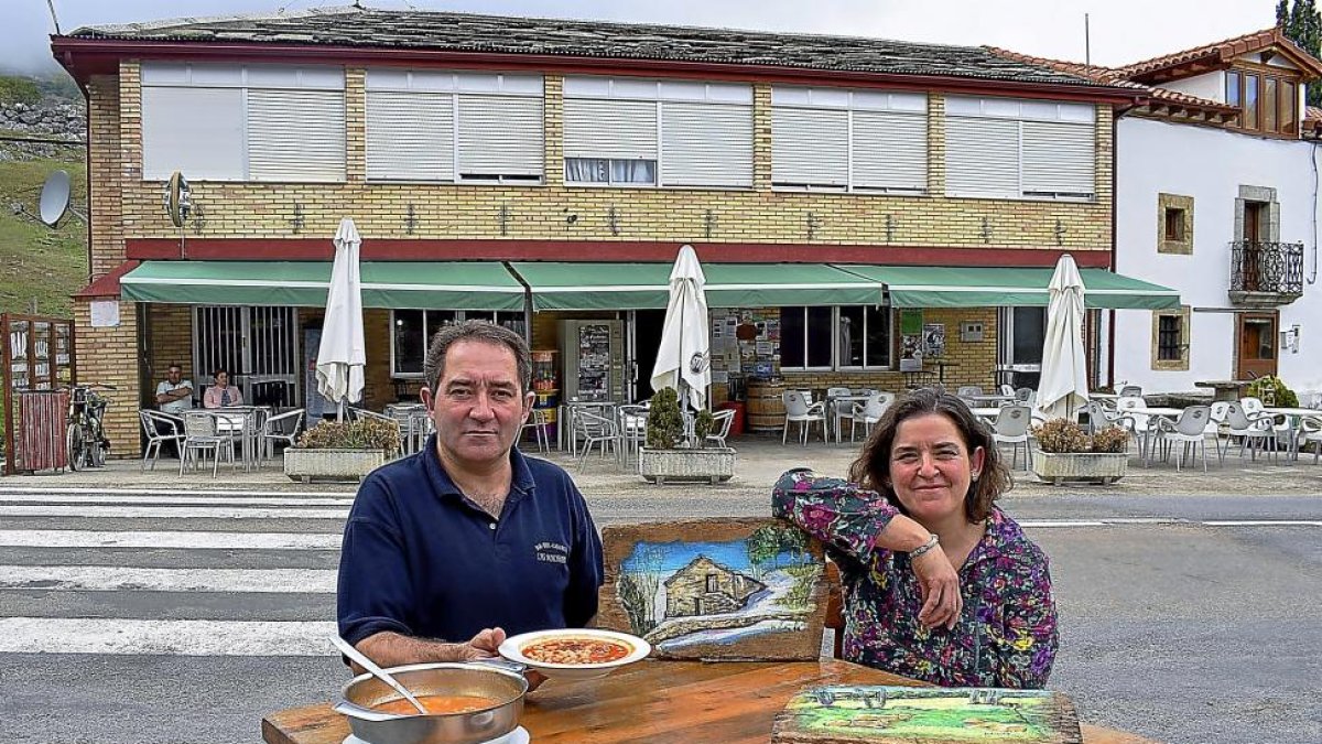 :Juanfran, con algunos platos del menú, y Lidia, con sus cuadros, en el exterior del restaurante.-ARGICOMUNICACIÓN
