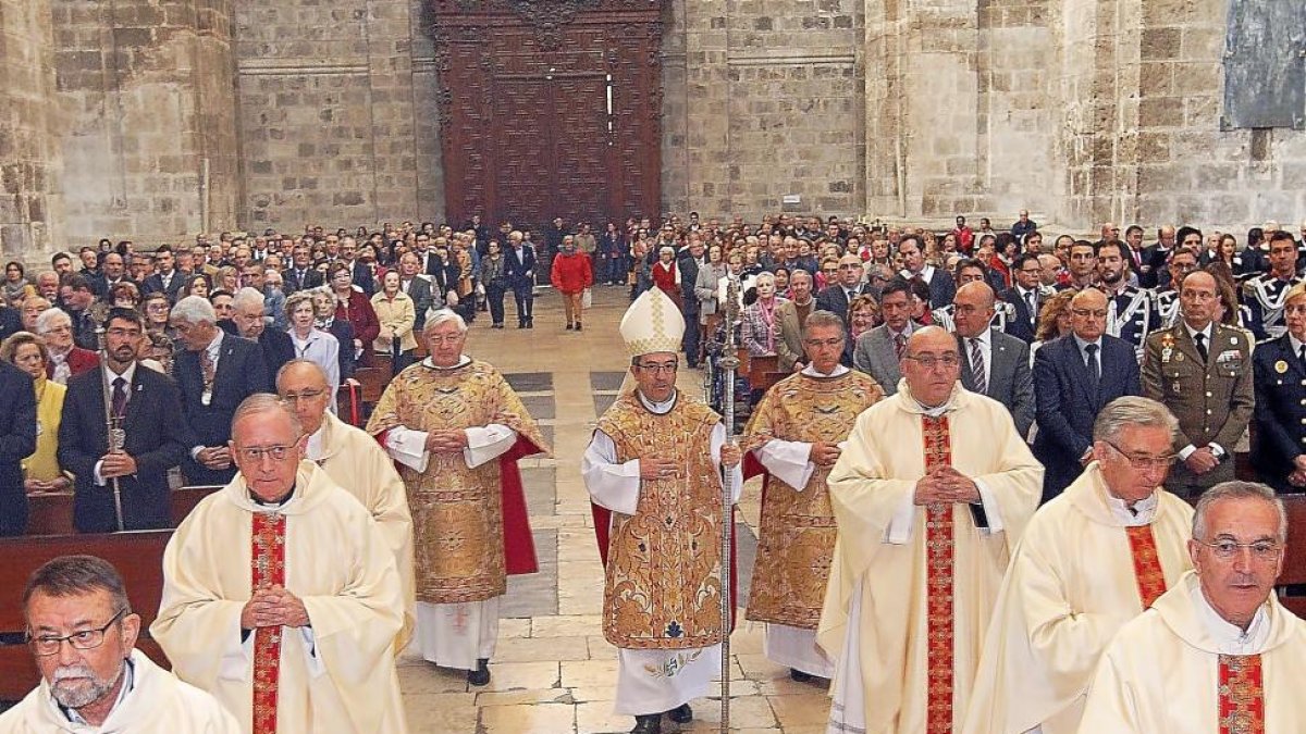 El obispo auxiliar, Luis Argüello, flanqueado por presbíteros, se dirige al altar mayor de la Catedral-