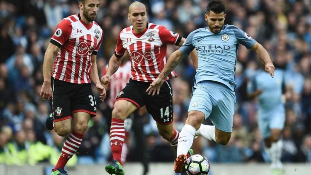 Agüero, que ha vuelto a la titularidad, conduce el balón perseguido por Oriol Romeu, del Southampton.-REUTERS / OLI SCARFF