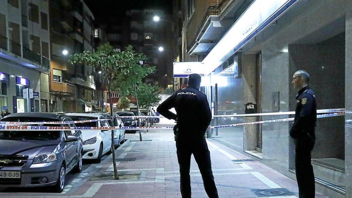 Dos agentes ante el precinto de seguridad puesto por la Policía Nacional minutos después de la reyerta.-J.M. LOSTAU