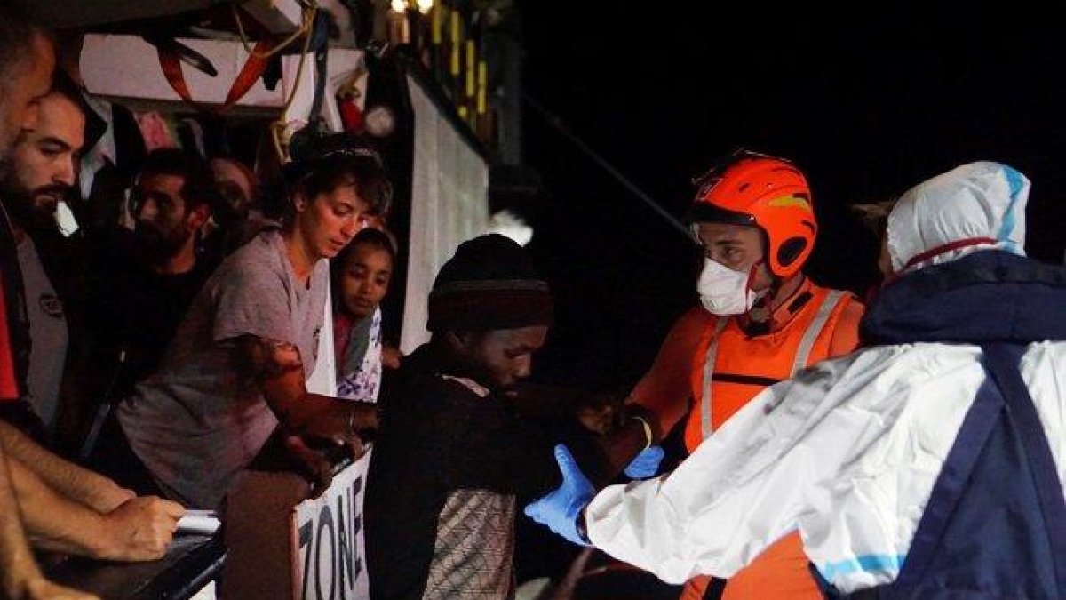 Efectivos de la Guardia Costera proceden a la evacuación de 8 personas necesitadas de asistencia urgente que permanecían en el barco de la ONG española Open Arms, que sigue bloqueado desde hace 18 días frente a la isla italiana de Lampedusa.-EFE/FRANCISCO GENTICO (EFE)