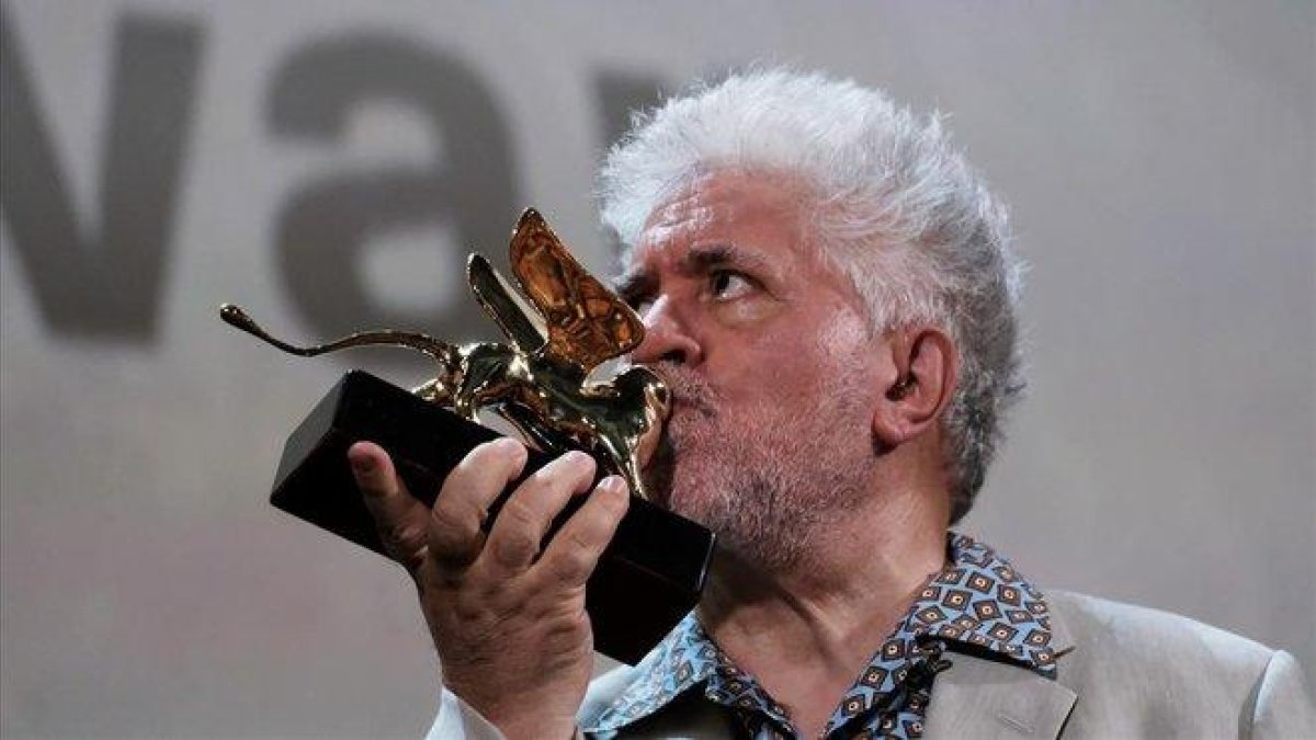 Pedro Almodóvar besa el León de Oro a su carrera cinematográfica, en Venecia, este jueves.-MANUEL SILVESTRI