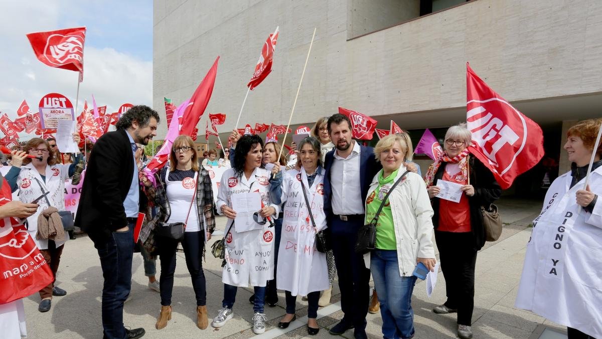 El presidente del PSOE de Castilla y León, Luis Tudanca, y el secretario regional de IU, José Sarrión, conversan con los trabajadores de ayuda a domicilio que se concentran a las puertas de las Cortes de Castilla y León-Leticia Pérez / ICAL