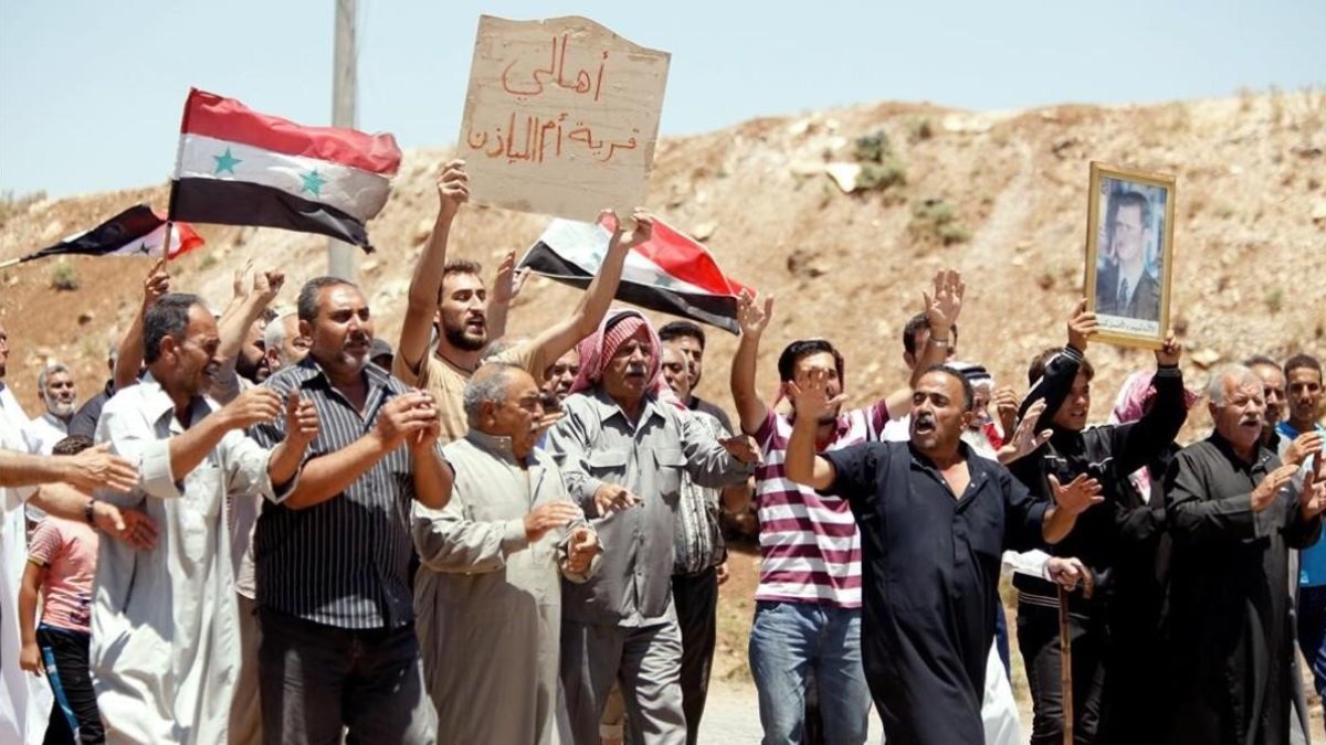 Un grupo de civiles celebra la entrada de las tropas del régimen en Deraa. /-OMAR SANADIKI / REUTERS