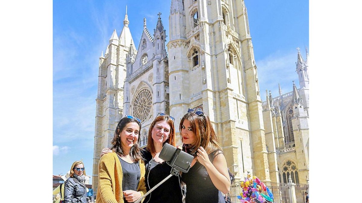 Turistas en León fotografiándose frente a su catedral.-ICAL