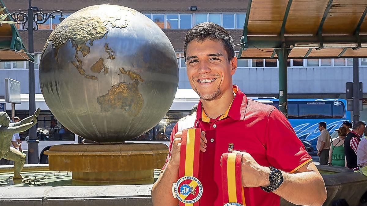 Miguel Cuadrado posa con sus cinturones de campeón nacional junto a la bola del mundo de Plaza España.-PABLO REQUEJO