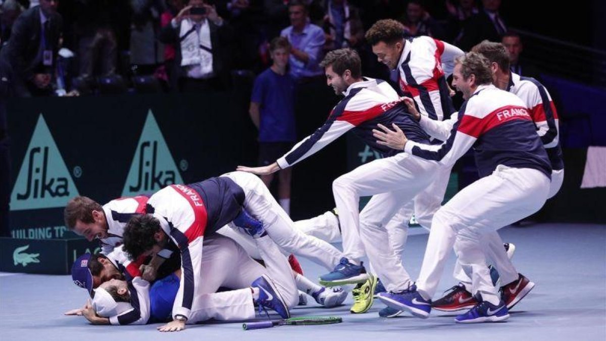 El equipo francés se abalanza sobre Lucas Pouille tras conseguir el punto definitivo sobre Steve Darcis en la final de la Copa Davis.-AP / CHRISTOPHE ENA