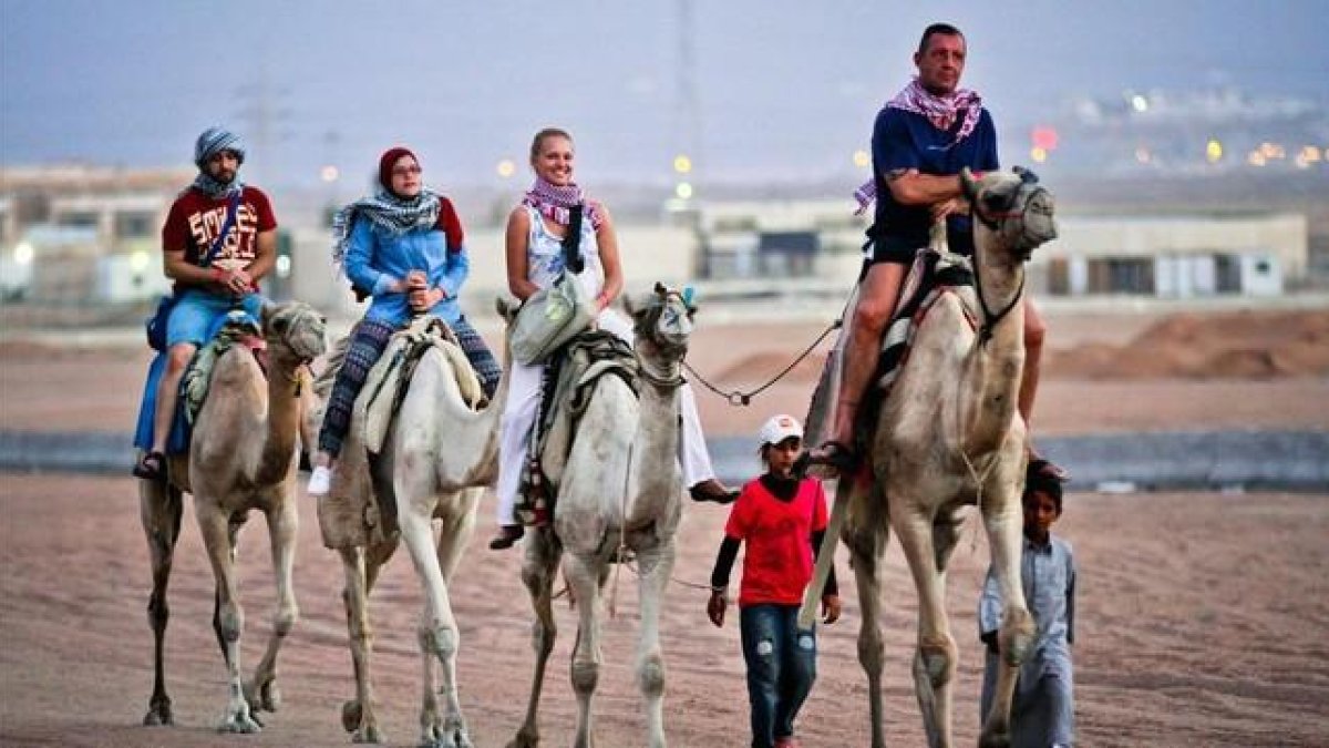 Turistas pasean en camellos en la ciudad egipcia de Sharm el Sheij.-AFP