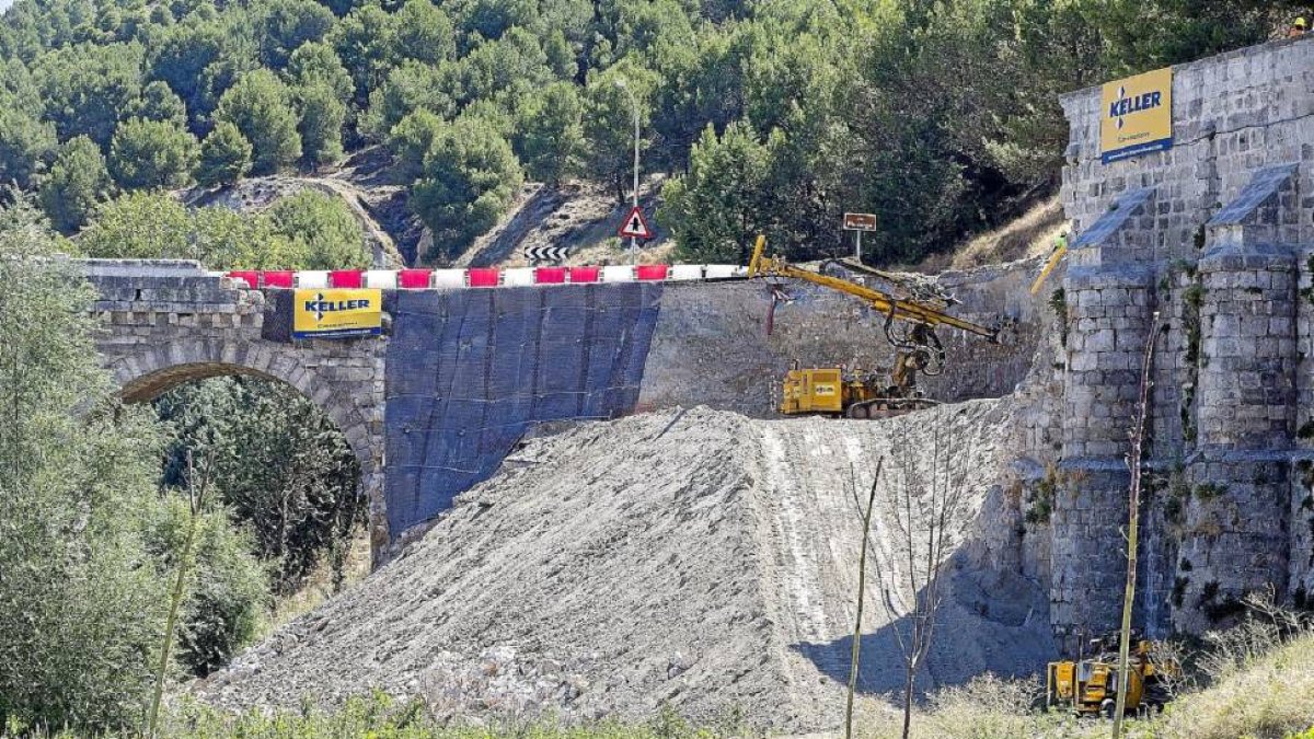 Las primeras máquinas limpiando el terreno ayer en el muro derribado del puente romano de Cabezón.-Pablo Requejo
