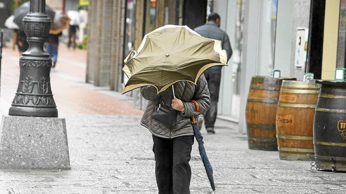 Una mujer se protege del viento en Ponferrada.-CÉSAR SÁNCHEZ