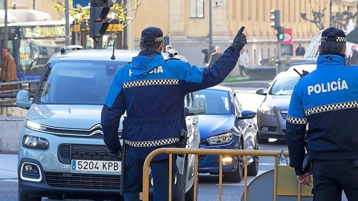 Foto de dos agentes cortando el tráfico en el centro de la ciudad por el episodio de contaminación.-PABLO REQUEJO