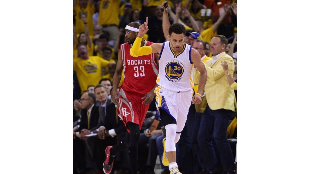 El jugador de los Warriors de Golden State Stephen Curry (c) celebra tras encestar contra los Rockets de Houston, durante el quinto partido de las finales de la Conferencia.-Foto: EFE