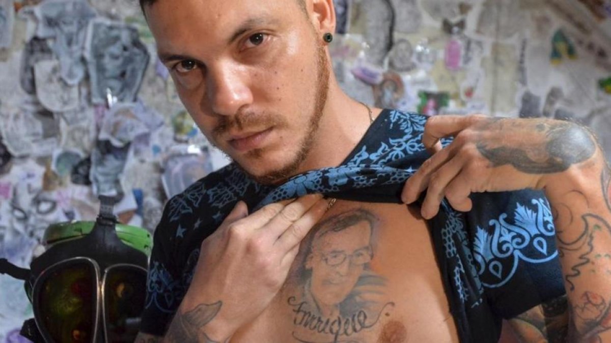 El hijo de Ismael Enrique Arciniegas, el colombiano de 74 años condenado a muerte en China por tráfico de drogas, muestra el tatuaje con el rostro de su padre.-AFP