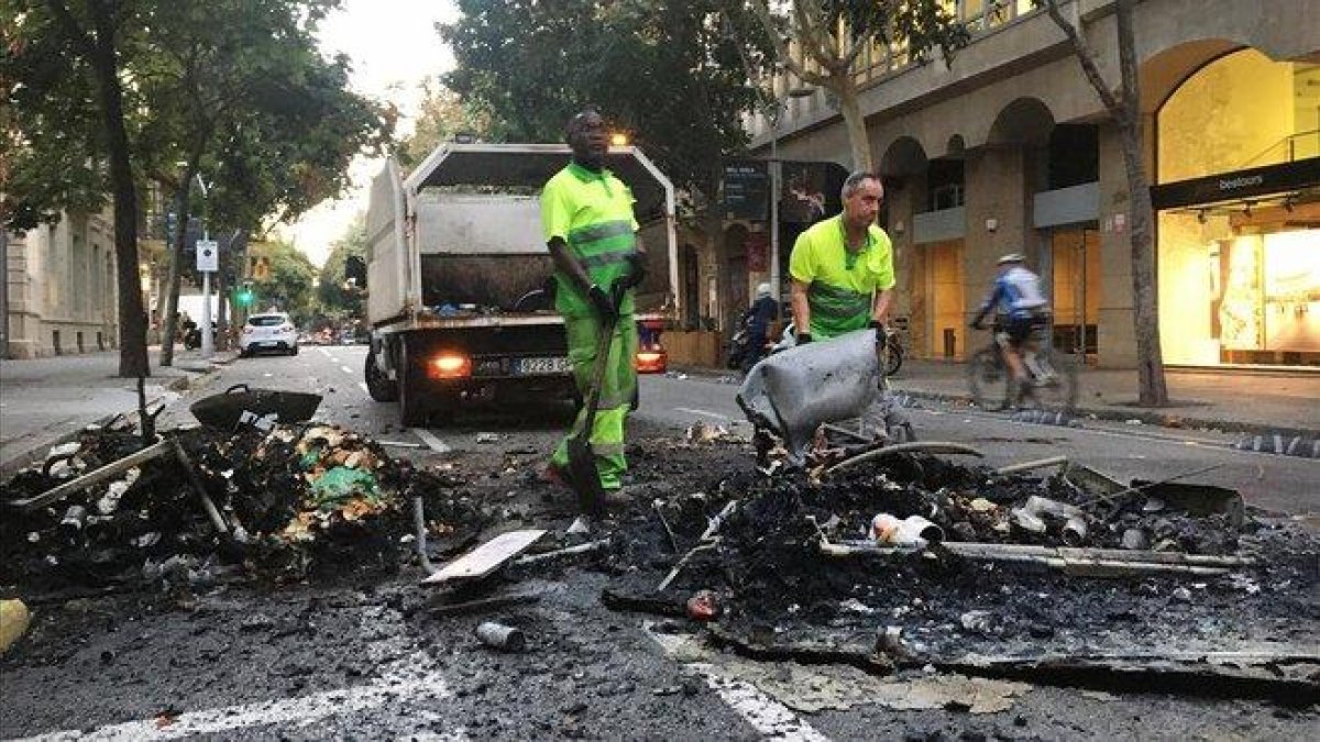 Una brigada de limpieza, en la calle de Consell de Cent con Pau Claris.-JOAN CORTADELLAS