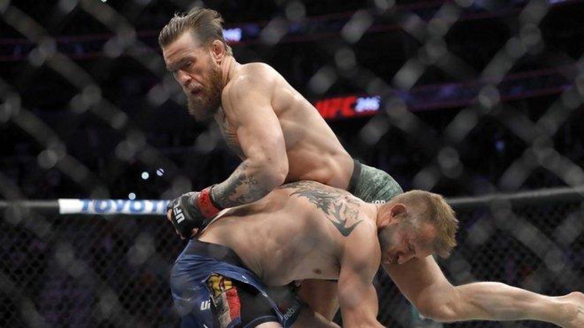 Conor McGregor (arriba) domina a Donald Cerrone en el combate celebrado en el T-Mobile Arena de Las Vegas.-AFP / STEVE MARCUS