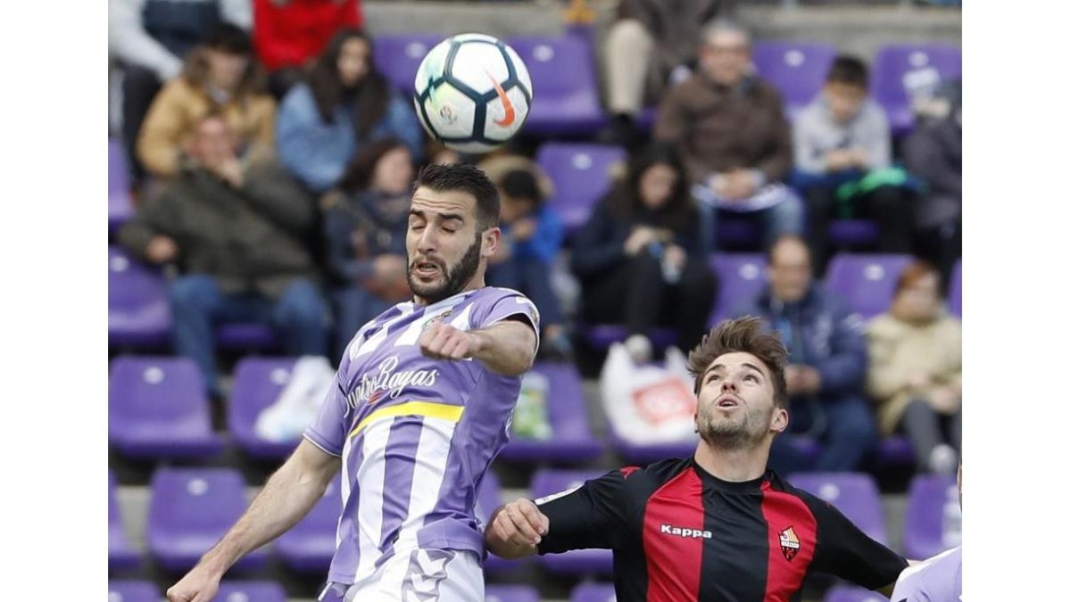 Antoñito se eleva por encima del reusense Fran Carbiá para despejar de cabeza el balón.-J.M.LOSTAU