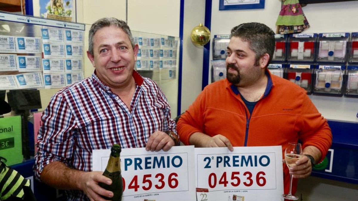 El propietario del despacho de lotería y cafetería Café de la Suerte, Manuel Martínez (I), vendedor de cinco décimos agraciados con el segundo premio de la Lotería de Navidad, junto a uno de los afortunados-Carlos S. Campillo / ICAL
