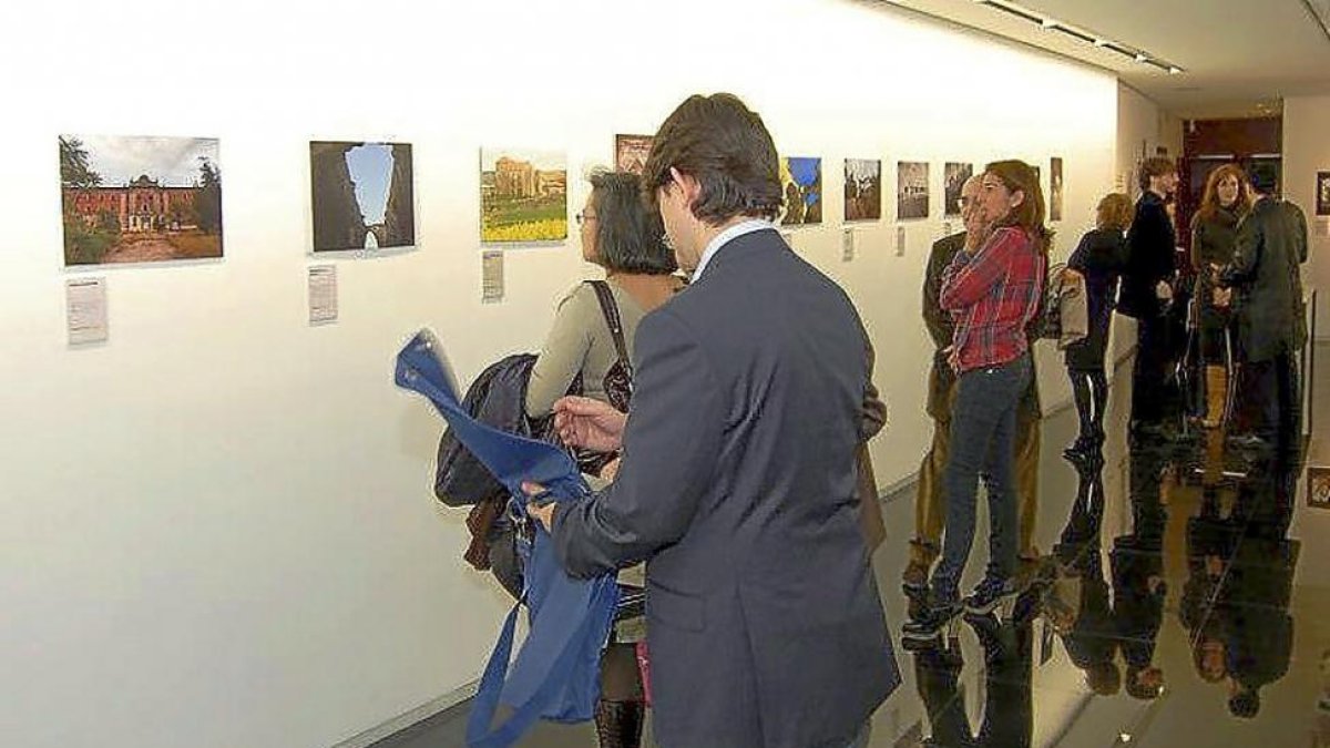 Miembros de la asociación en la exposición del certamen fotográfico.-EL MUNDO