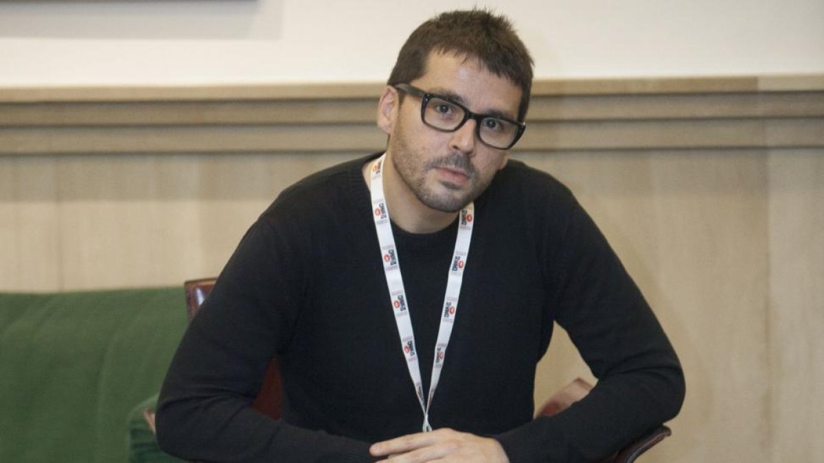 Aitor Rei muestra el cartel de su documental. Abajo, fotograma de la película con afectados por el accidente de tren.-Pablo Requejo