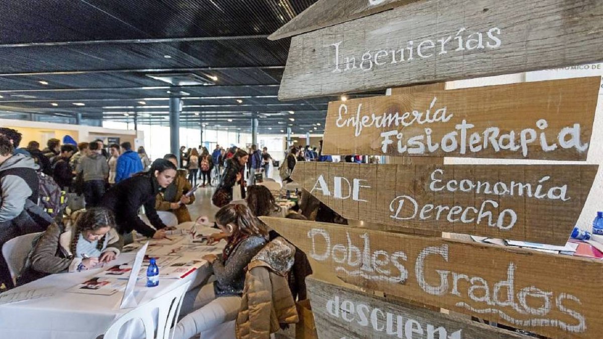 Un grupo de jóvenes consulta la oferta de grados de una de las universidades de Castilla y León en el vestíbulo de la Feria de Valladolid-Miguel Ángel Santos