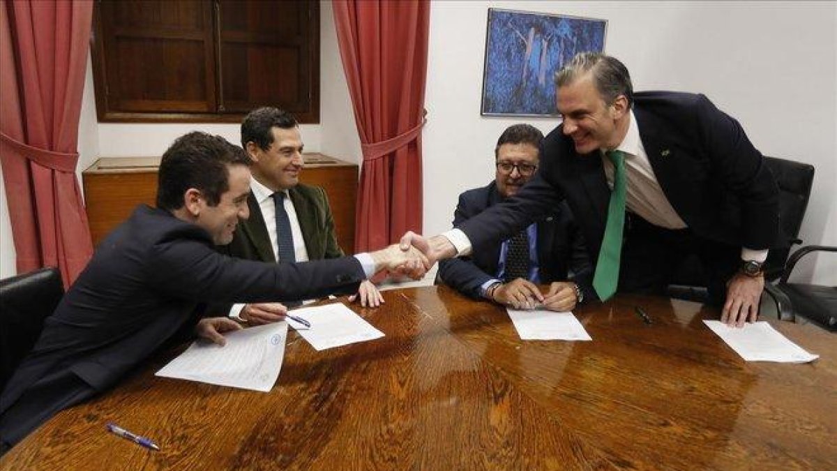 Los secretarios generales del PP, Teodoro García Egea, y de Vox, Francisco Javier Ortega Smith, estrechan las manos delante de los líderes andaluces del PP, Juanma Moreno y de Vox, Francisco Serrano, durante una reunión.-EFE / JOSE MANUEL VIDAL